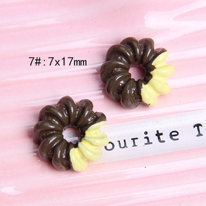 Macro shot of 7x17mm resin donut charms with brown and cream spiral textures for DIY craft