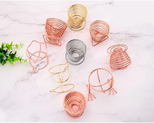 Detail view of metal beauty blender holders in gold and rose gold on marble surface
