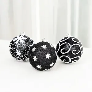 Set of three black Christmas balls with white snowflake and swirl glitter patterns