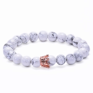 Detail of white howlite beaded bracelet with a rose gold crown charm and crystals