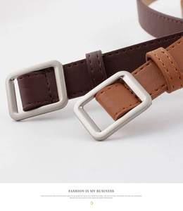 Close-up of minimalist square silver buckles on dark and light brown leather belts