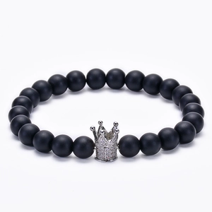 Detailed close-up of matte black beads bracelet with silver zircon crown charm