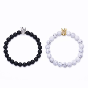 Detailed macro view of 8mm white turquoise and matte stone bracelets with crown charms