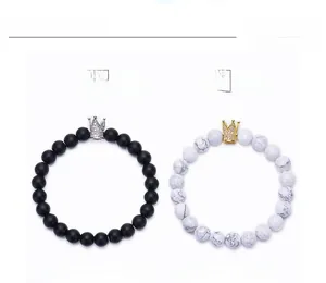 Detail of 8mm matte black stone and white turquoise bracelets with crown charms