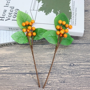 Artificial orange berry stems with green leaves for home holiday decoration