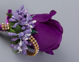 Close-up of purple satin rose boutonniere with silk ribbons and sparkling crystal rings