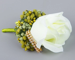 Detail of silk white rose boutonniere with green berries and luxury rhinestone base