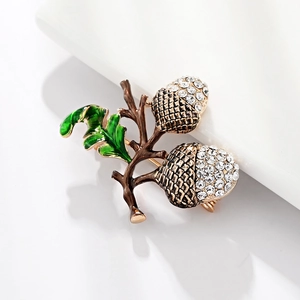 Sparkling acorn and green leaf hazelnut brooch with crystal rhinestones on white background