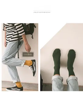Close-up of mustard yellow and dark green cotton socks featuring elastic knit texture