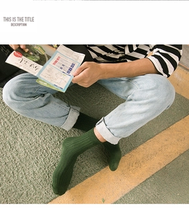 Detailed texture of dark green ribbed knit cotton crew socks worn with denim jeans