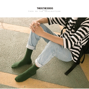 Detail of forest green ribbed cotton socks worn with jeans in a vintage outdoor setting