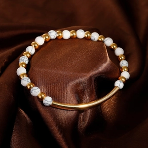 Elastic bead bracelet with white marble stones and gold curved metal tube on silk