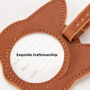 Detail of a brown leather cat-ear luggage tag with precision stitching and ID card window