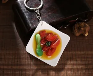 Close-up of realistic braised pork food model keychain with a metal ring on wood background