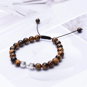 Macro detail of tiger eye beads with silver dumbbell charm and adjustable black cord