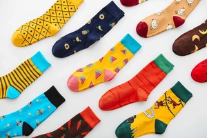 Flat lay of colorful mid-calf cotton socks with various cute fruit and animal patterns