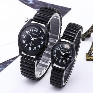 Close-up of black luminous couple watches with elastic bands and clear Arabic numerals