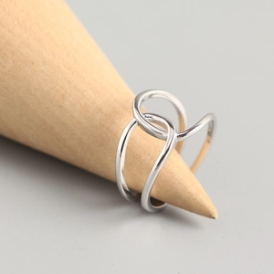 Minimalist S925 sterling silver criss cross ring displayed on a wooden cone stand