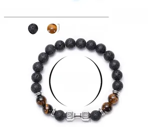 Detail of lava rock and tiger eye beaded fitness bracelet with silver dumbbell charm