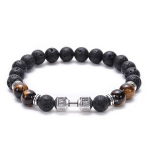Macro shot of lava stone bracelet with tiger eye beads and engraved metal dumbbell charm