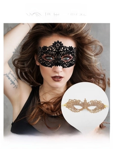 Detailed view of intricate black lace mask with floral patterns and gold ribbon ties