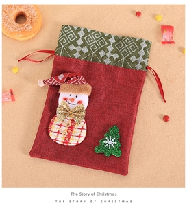 Detail of burlap Christmas gift bag with a 3D snowman and festive drawstring closure