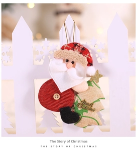 Detail of Christmas Santa plush ornament with Merry Christmas burlap tree on a white fence