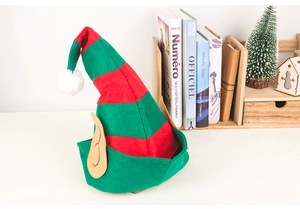 Detail of red and green striped elf hat with ears and white pompom in festive decor
