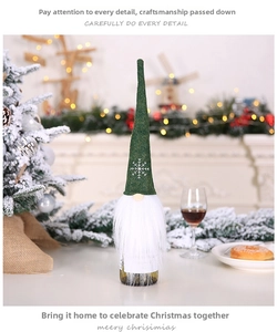 Detailed close-up of dark green felt gnome wine bottle cover with snowflake embroidery