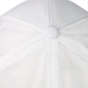 Macro detail of the top button and stitched seams on a white twill cotton baseball cap