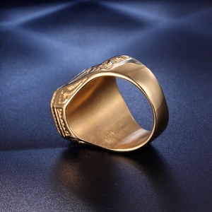 Dettaglio macro di anello punk dorato da uomo con rilievo vintage e interno spazzolato