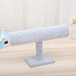 Detail view of T-bar jewelry display stand with gray velvet finish on a wooden desk