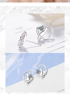 Macro detail of silver moon and cat stud earrings with sparkling round zircon stone