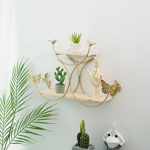 Golden metal wall shelf with bird and butterfly accents and light wood tiers