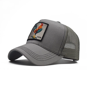 Detail of embroidered rooster patch on grey mesh trucker cap with breathable back