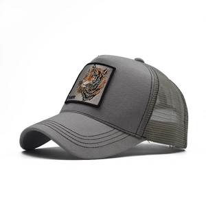Side view of grey trucker hat featuring a detailed tiger embroidery patch and mesh back