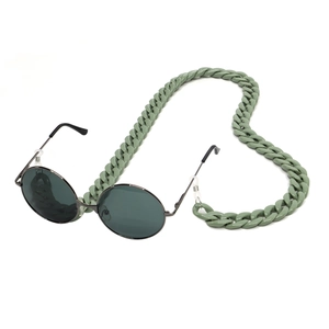 Close-up of bean green acrylic eyewear chain attached to black frame sunglasses