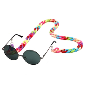 Close-up of a colorful acrylic chain attached to black round sunglasses on white background
