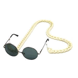 Detail of cream acrylic chain linked to black sunglasses in retro chunky style