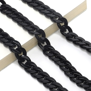 Macro detail of glossy black acrylic thick chain links on book edge for glasses strap