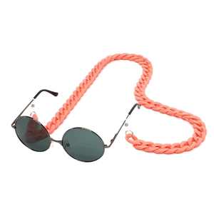 Detail of peach acrylic eyewear chain with oversized links and black round sunglasses