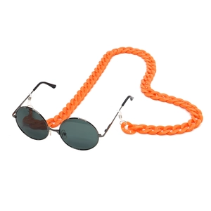 Orange acrylic eyewear chain shaped into a heart on white background with sunglasses