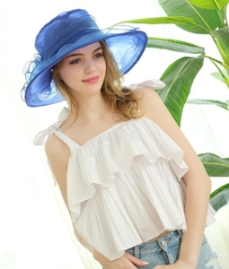 Close-up of royal blue organza sun hat with flower details and wide brim design