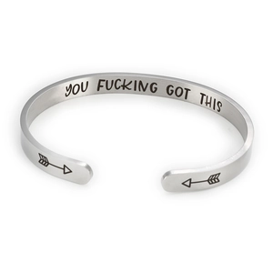 Macro detail of 6mm stainless steel cuff bracelet with engraved inspirational quote inside