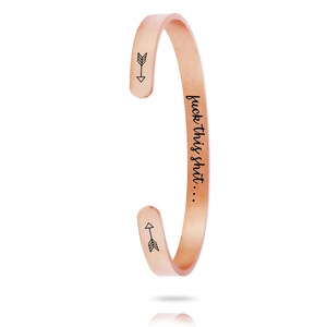 Detail view of rose gold C-shaped cuff bracelet with laser engraving and arrow icons
