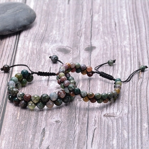 Faceted indian agate beaded bracelets with adjustable woven cords on a rustic wooden desk