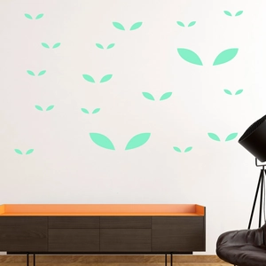 Detailed view of light green leaf wall decals in a modern living room setting