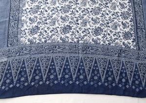 Detailed macro view of the intricate blue and white floral batik patterns on the linen scarf