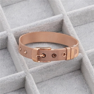 Macro shot of rose gold Milanese mesh bracelet with buckle on grey jewelry tray