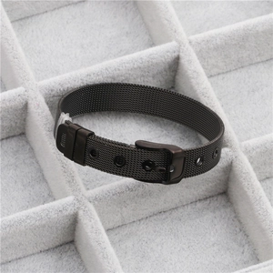 Detail of adjustable black stainless steel mesh watch-strap style bracelet on grey velvet